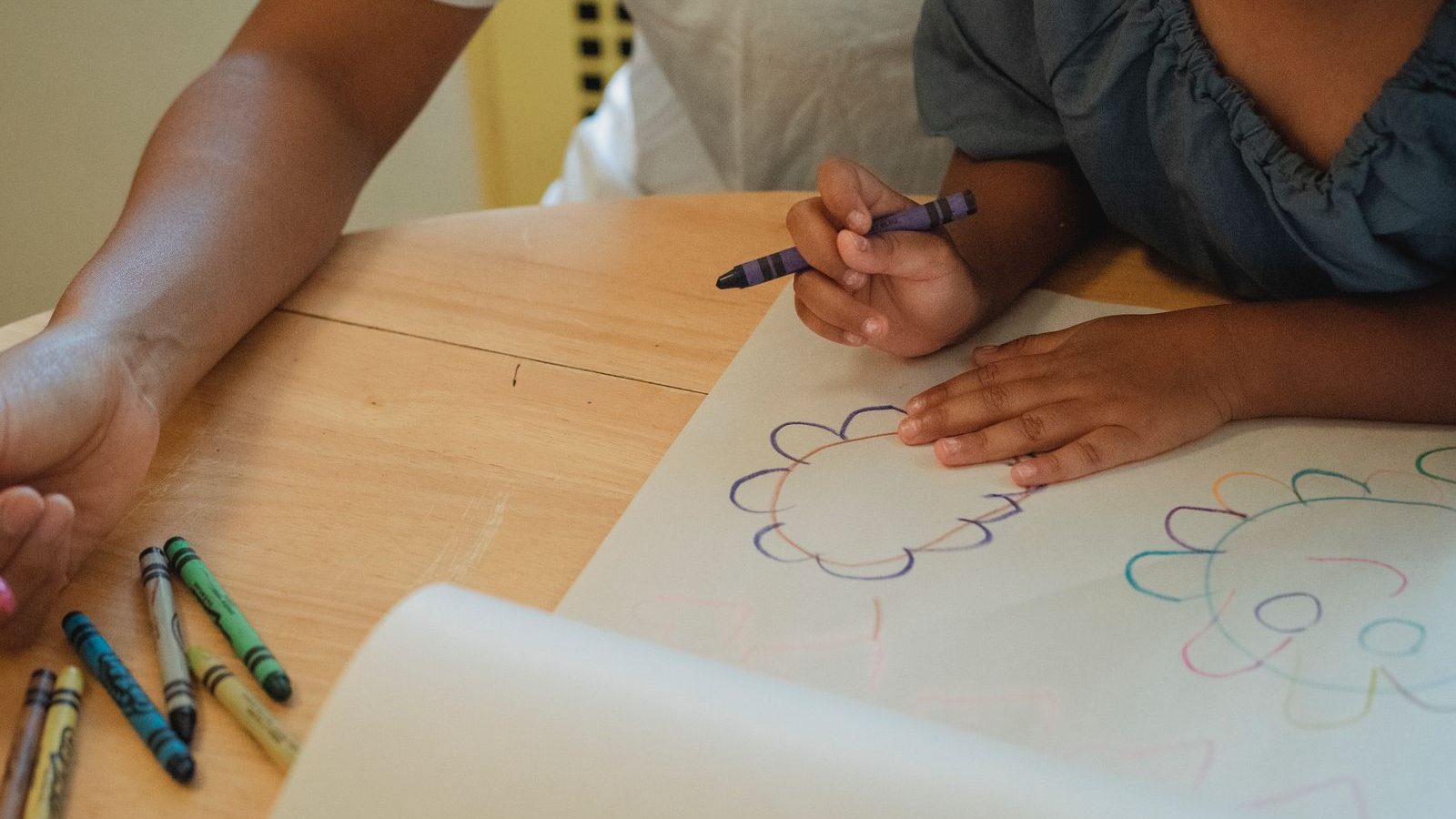 Parent and child drawing together at a table