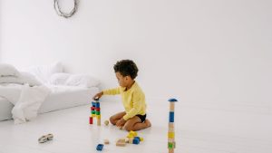 Child building with colorful wooden blocks at home