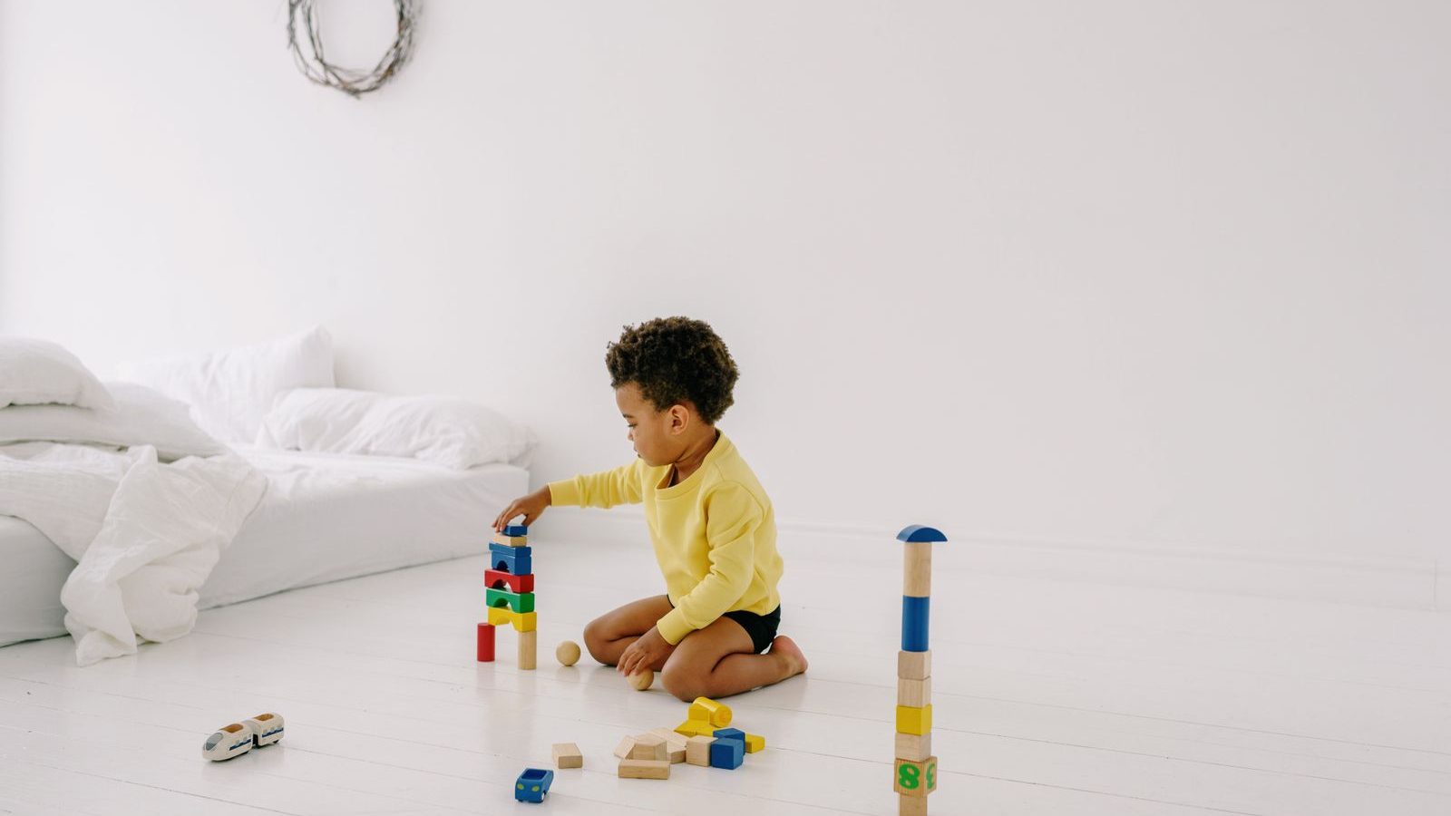 Child building with colorful wooden blocks at home