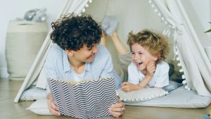 Parent reading a picture book with a preschooler indoors