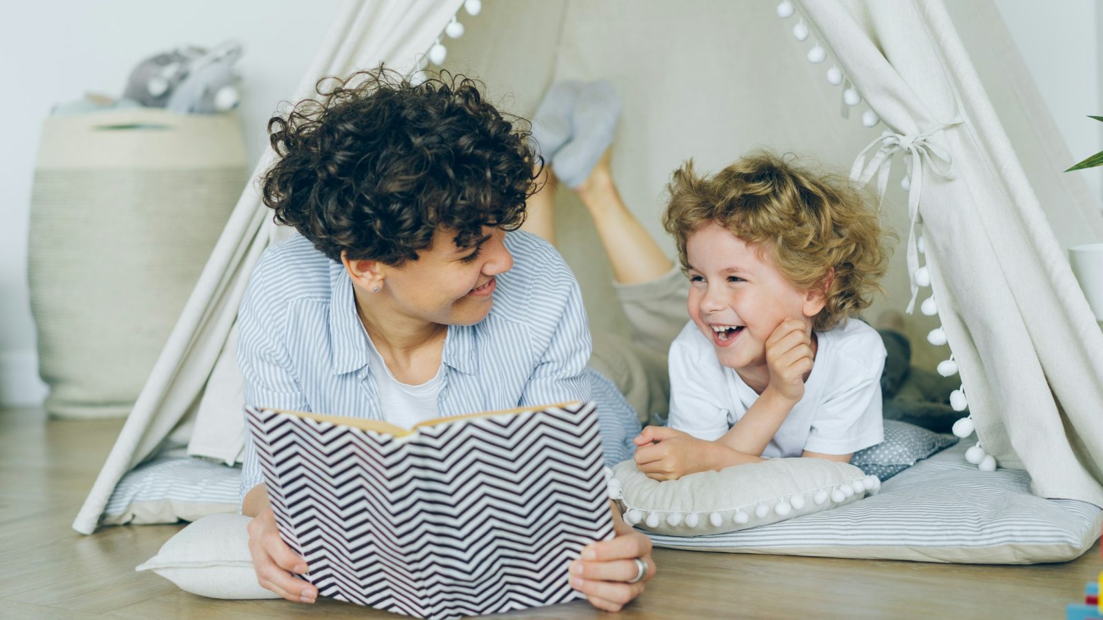 Parent reading a picture book with a preschooler indoors