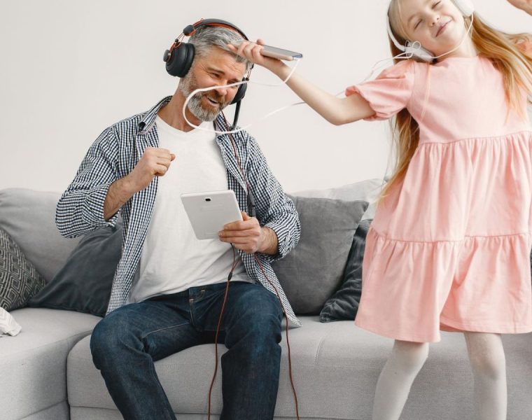 Parent and child dancing and laughing together at home