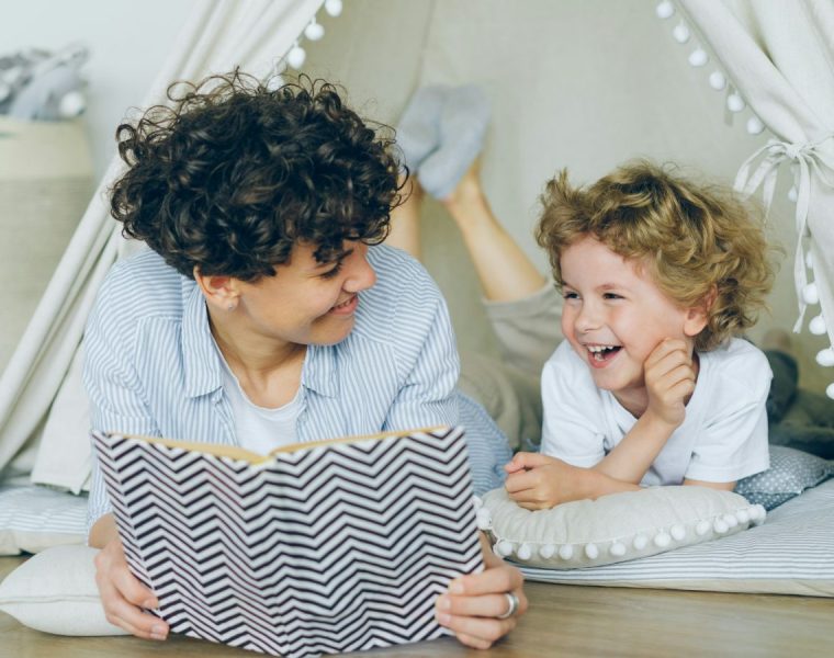 Parent reading a picture book with a preschooler indoors